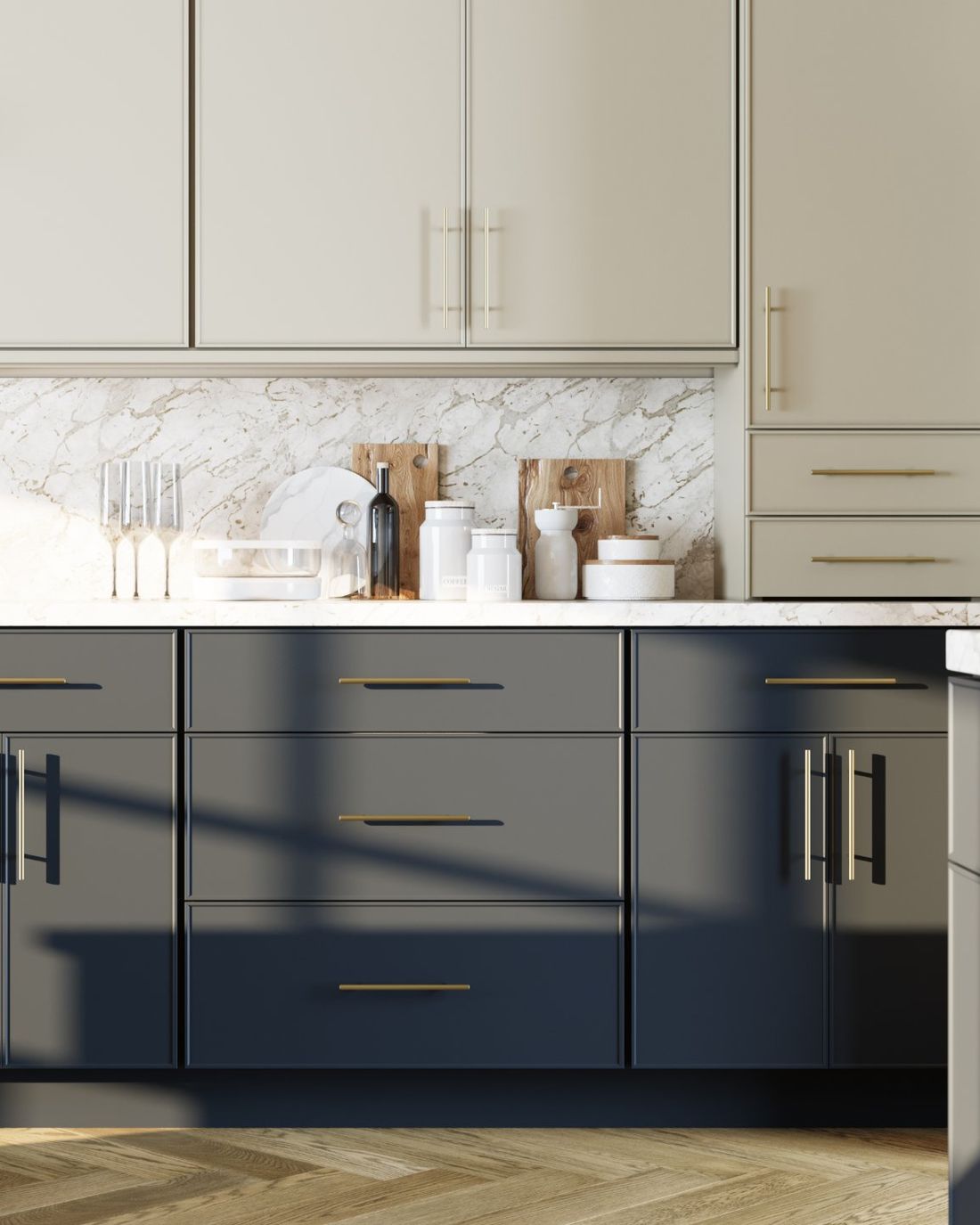 Two-tone cabinetry detail with navy base cabinets, brass pulls and a marble backsplash